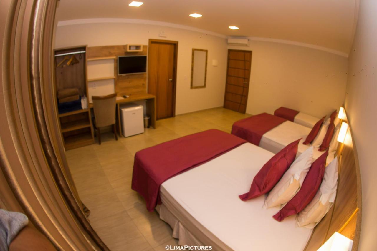 Quarto amplo com cama de casal e camas de solteiro