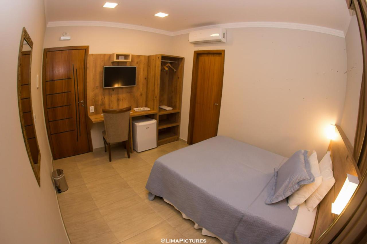 Quarto de casal com escrivaninha, TV de tela plana e frigobar