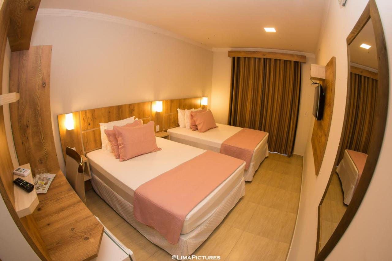 Quarto com duas camas e espelho de corpo inteiro