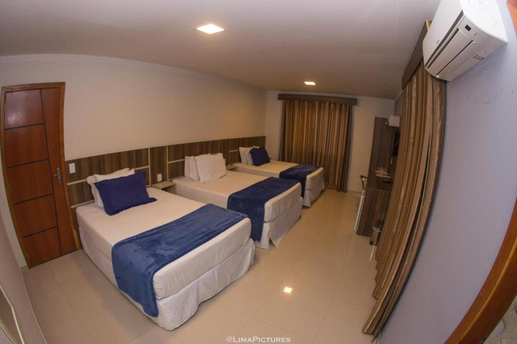 Quarto com três camas e ar-condicionado