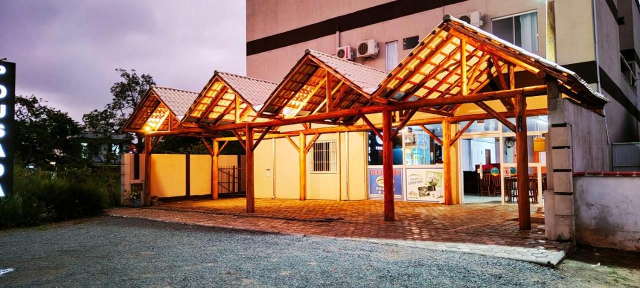 Fachada da Do Parque Pousada Slim ao entardecer, na Armação do Itapocorói
