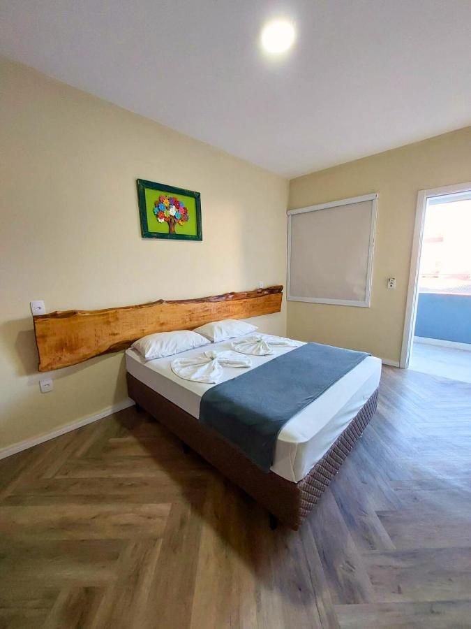 Quarto duplo da Do Parque Pousada Comfort com cabeceira de madeira rústica